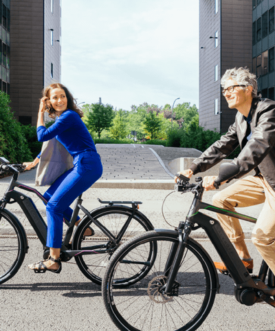 Ein Mann und eine Frau fahren auf E-Bikes mit Boschsystem durch die Stadt