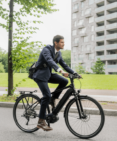 Ein Mann im Business Outfit fährt mit seinem Pedelec in Nürnberg zur Arbeit