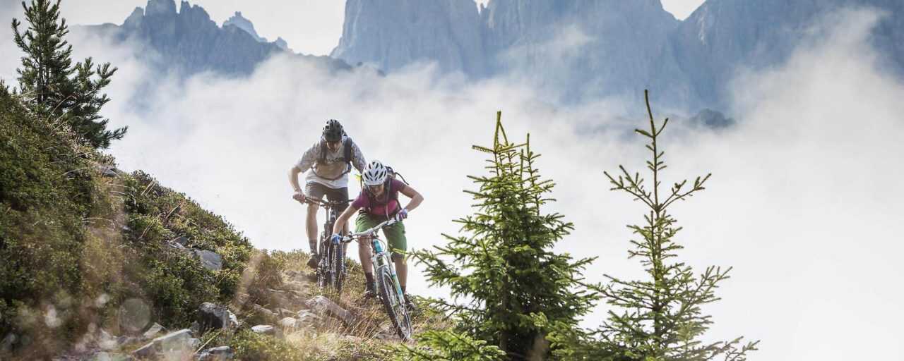 E-Mountainbike kaufen Zwei Personen mit E-Mountainbikes in den Bergen