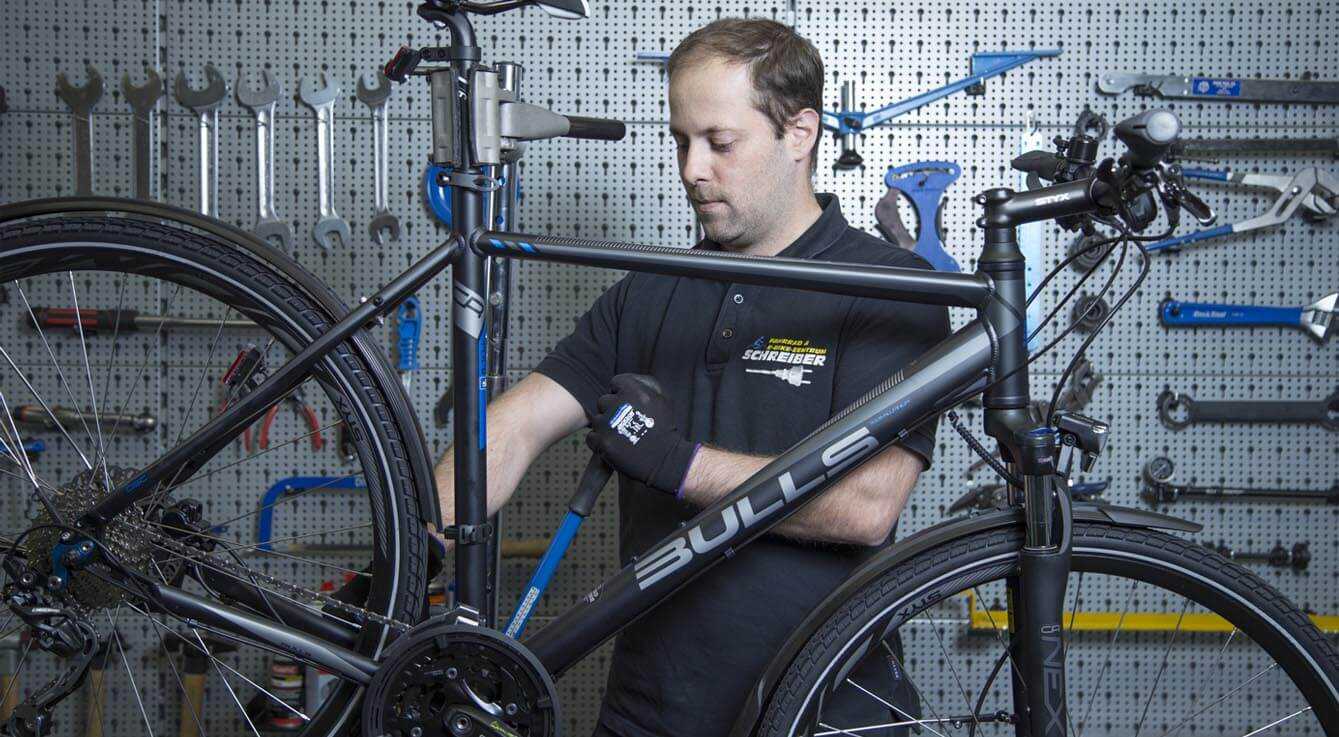 Fahrradmechaniker repariert ind der Fahrradwerkstatt Erlangen ein Fahrrad