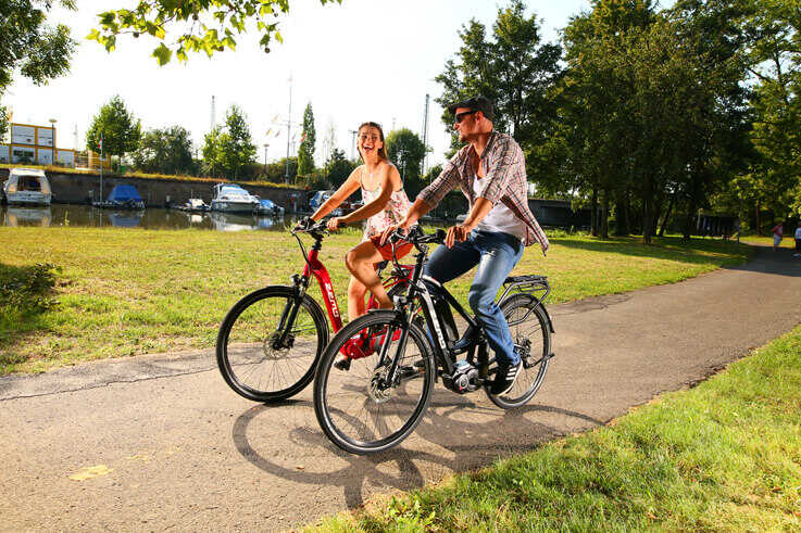 Frau und Mann fahren mit Zemo Pedelecs im Park