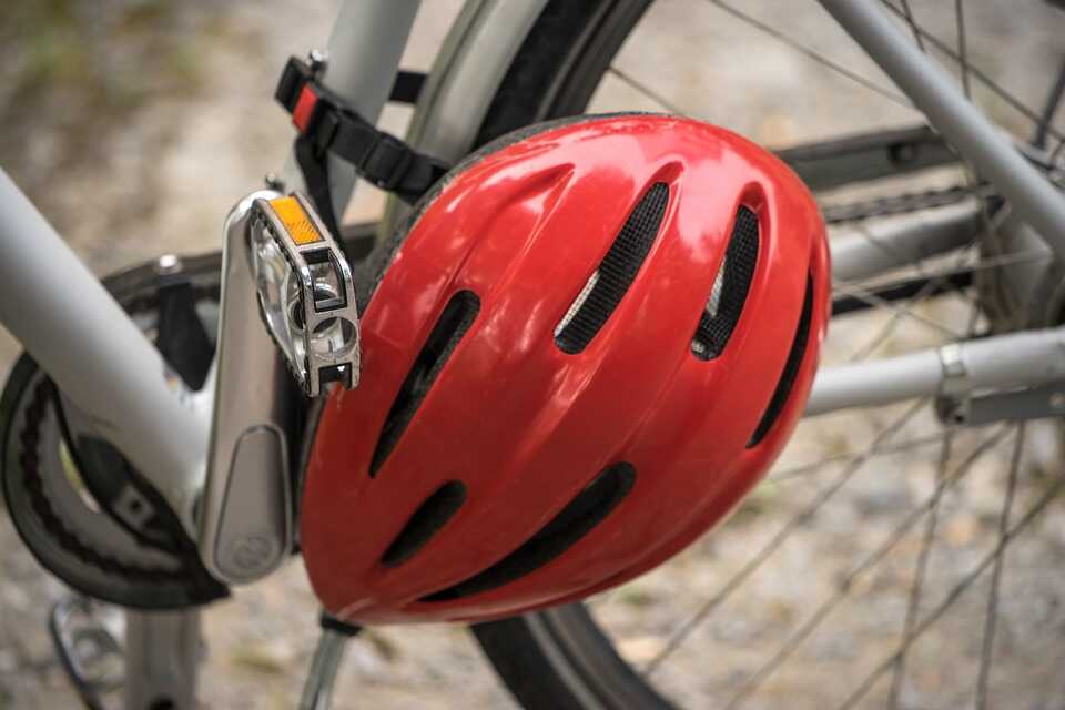 ein roter Fahrradhelm ist an einem silbernen Fahrrad befestigt