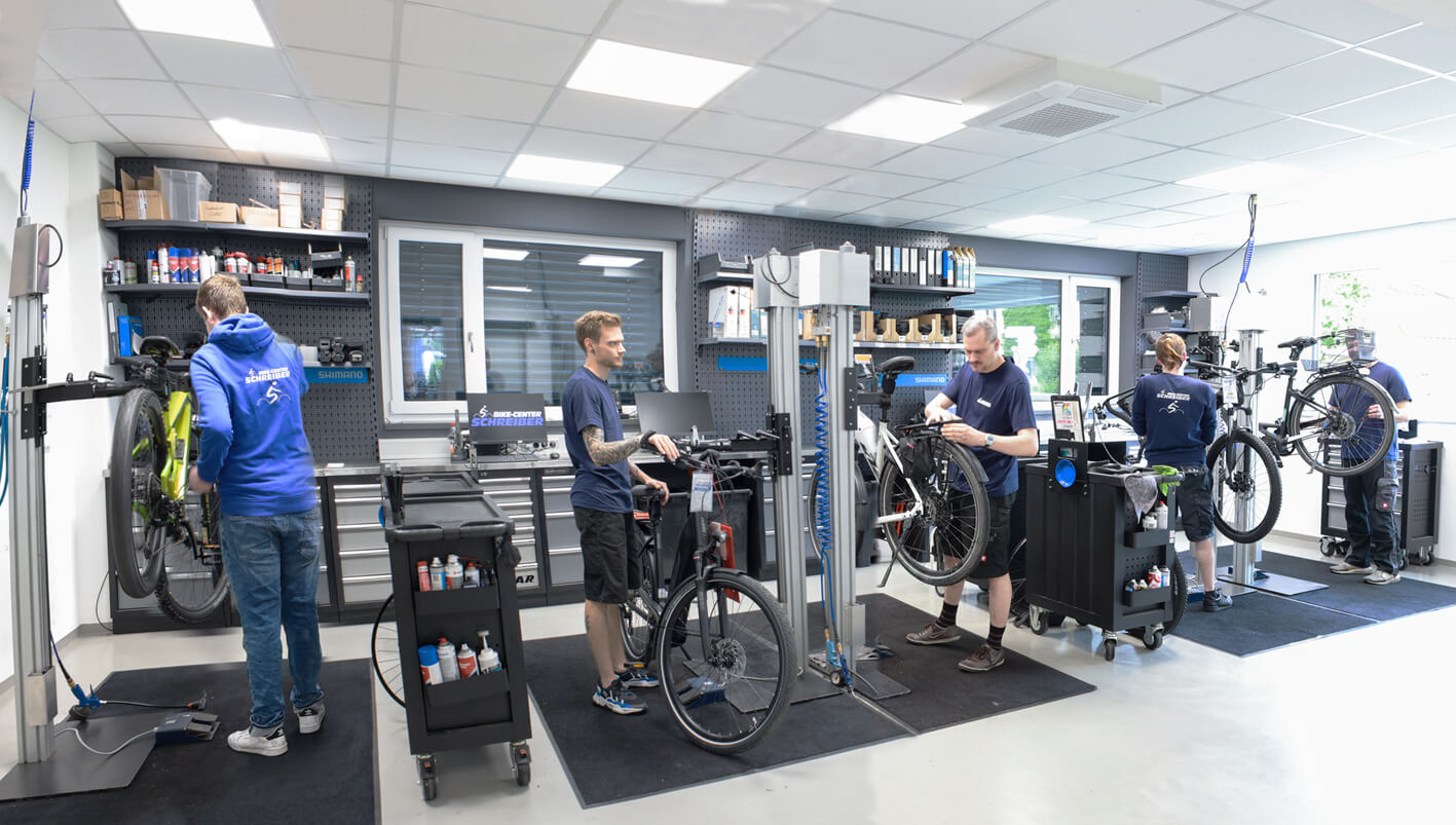 4 Mechaniker repariern E-Bikes in der Werkstatt