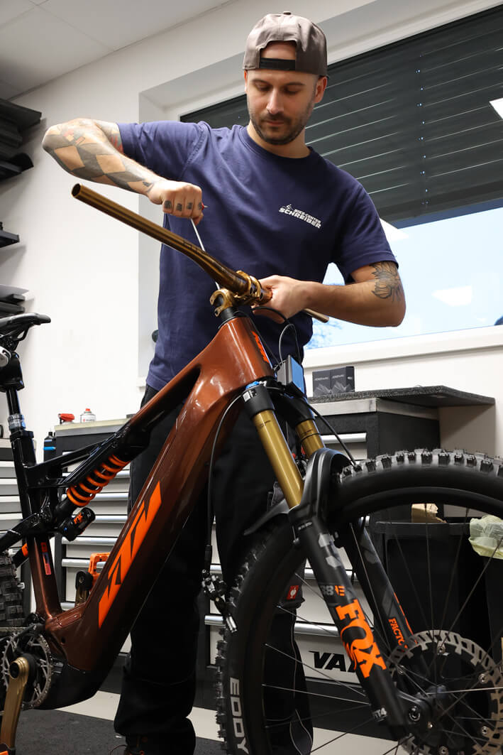 Zweiradmechaniker schraubt an einem KTM Prowler E-Bike