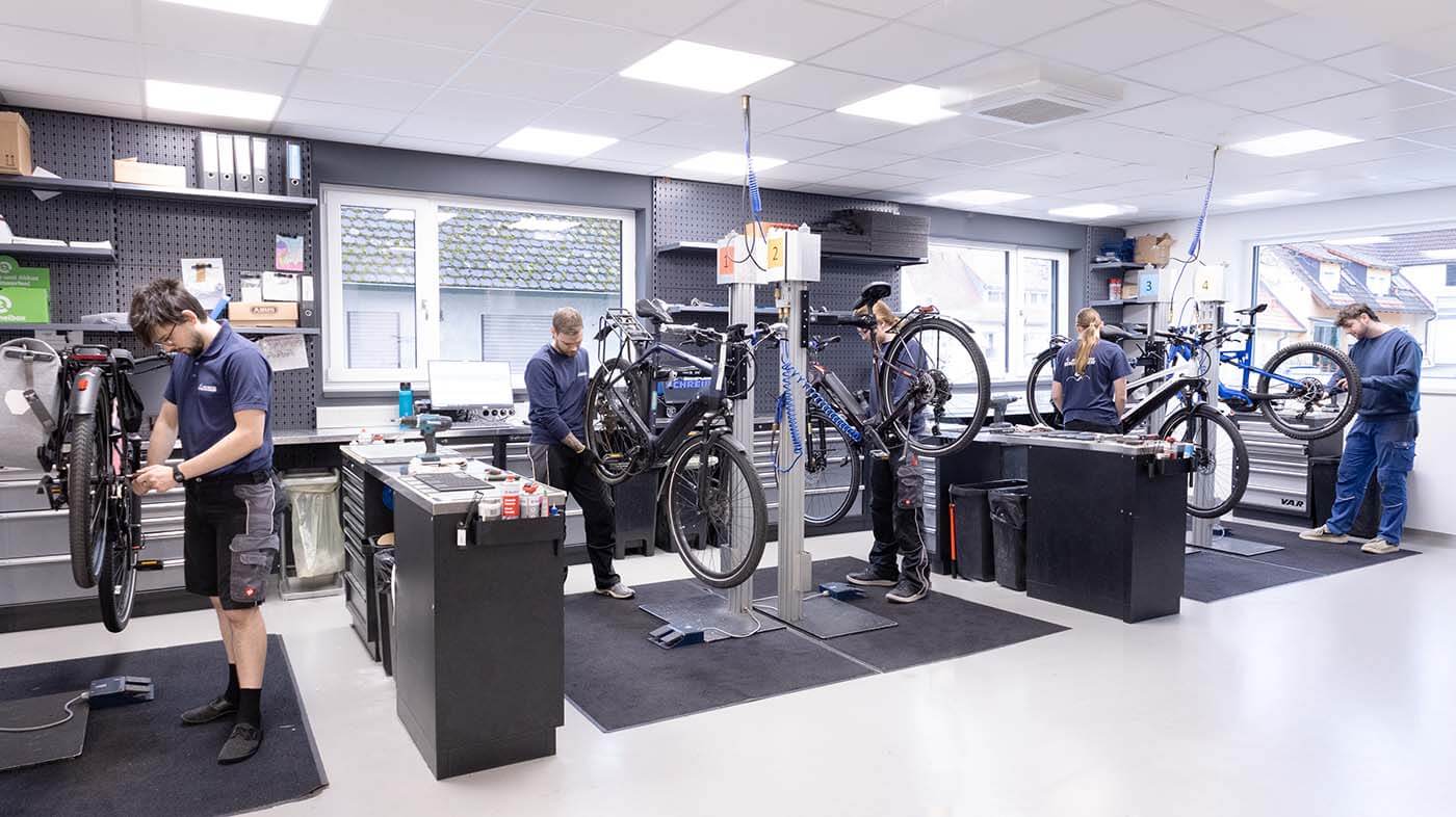 Fahrradwerkstatt Erlangen Fahrradwerkstatt mit fünf Mechanikern an ihren Arbeitsplätzen