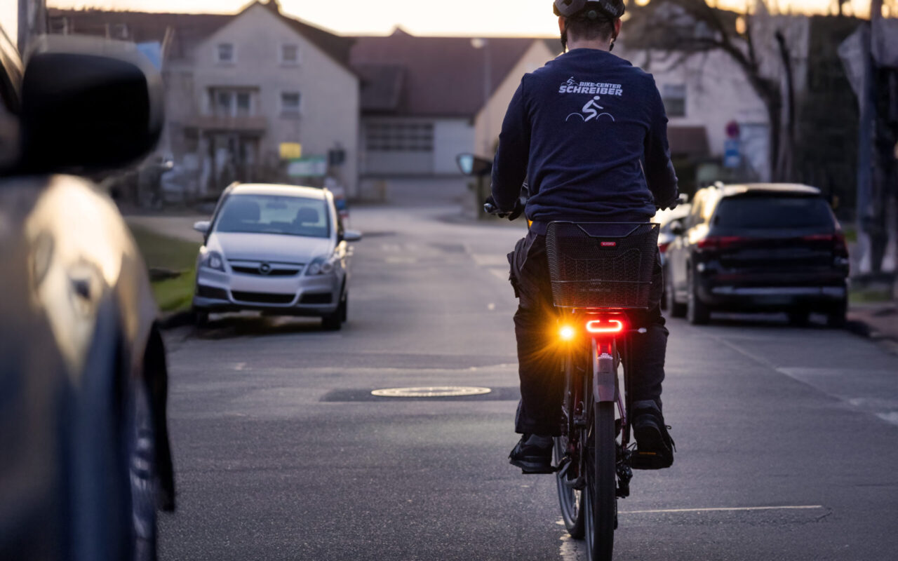 Blinker für E-Bikes Mehr Sicherheit mit dem Turntec von Busch & Müller Ein Mann fährt in der Dämmerung mit einem E-Bike, dieses ist mit einem aktiven Blinker ausgestattet.