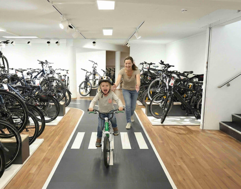 Kind testet woom Fahrrad auf Indoor-Strecke im Bike Center Schreiber